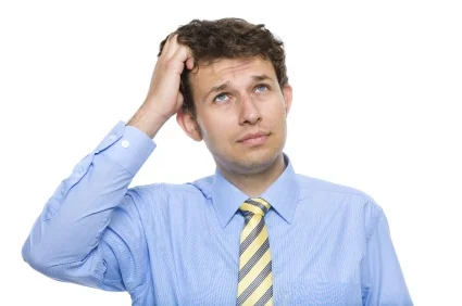 A man scratching his head from brain fog related to untreated sleep apnea.
