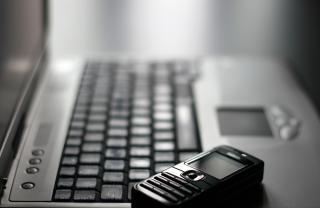 A mobile phone and keyboard, two sources of stress that lead to smoking and poor sleep in Friendswood.